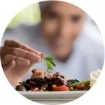 Chef decorating a plate with vegetables